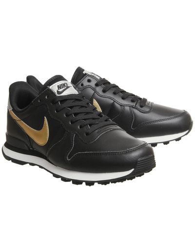 nike black and gold internationalist trainers