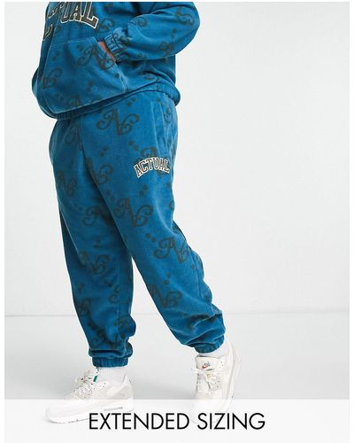 ASOS Asos Actual - Ruimvallende joggingbroek Van Polar Fleece Bedekt Met Print En Logo-applicatie - Blauw