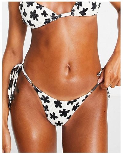 Kulani Kinis X hannah meloche – bikinihose mit hohem beinausschnitt, seitlicher schnürung und streublumenmuster - Schwarz
