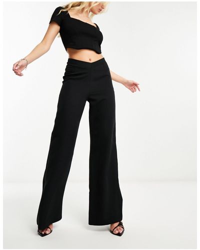 Naanaa Pantaloni con fondo ampio neri con dettaglio a v - Bianco