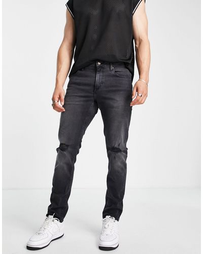 ASOS Jeans slim elasticizzati slavato con strappi sulle ginocchia - Nero