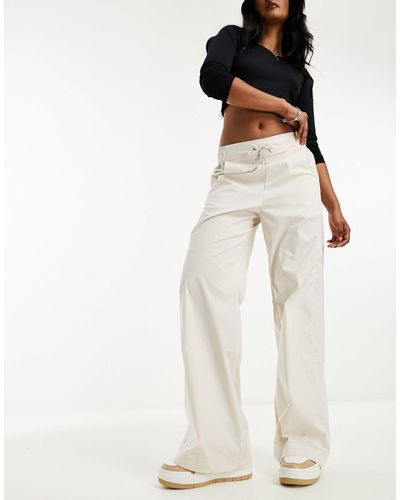 Nike Pantaloni a vita alta marrone legno chiaro con logo piccolo - Bianco