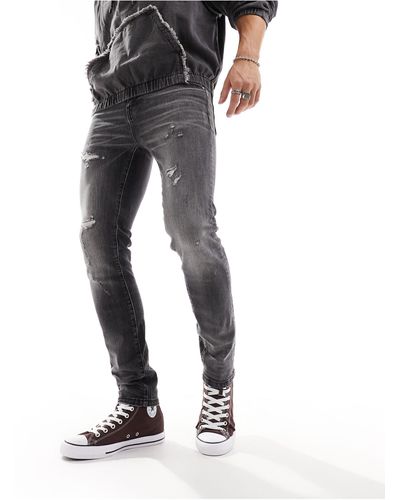ASOS Jeans skinny slavato vintage con abrasioni - Nero