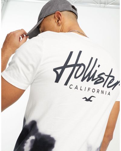 Hollister Camiseta larga blanca y negra con lavado ácido degradado y logo en el pecho y la espalda - Blanco