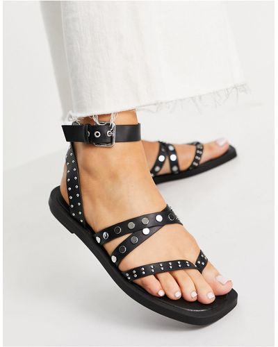 Schuh Tale - sandales plates cloutées à entredoigt et lanières - Noir