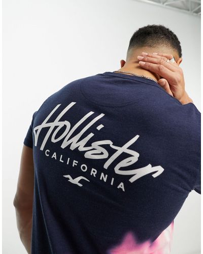 Hollister T-shirt taglio lungo blu sfumato lavaggio acido con logo sul petto e sul retro