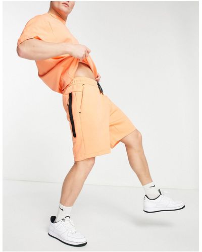 Nike Shorts naranja empolvado tech fleece