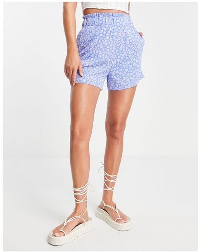 Monki – locker geschnittene shorts mit elastischem bund und leuchtendem hibiskus-blumenmuster - Blau