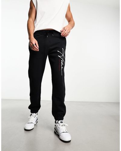 Hollister Jogger technique décontracté resserré aux chevilles avec logo sur les jambes - Noir
