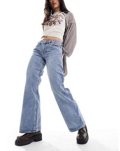 Monki Imoo - jean ample à taille basse - moyen délavé - Bleu