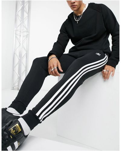 adidas Originals Adicolor - jogger coupe skinny à trois bandes - Noir
