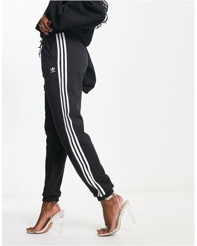 adidas Originals – adicolor – jogginghose mit engen bündchen und drei streifen - Schwarz