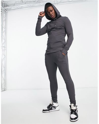 ASOS – trainingsanzug aus körperbetontem kapuzenpullover und super eng geschnittener jogginghose - Schwarz