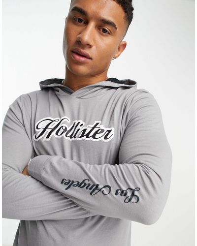 Hollister Top a maniche lunghe con cappuccio e scritta del logo - Grigio