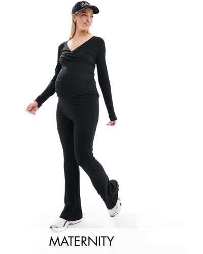 Mama.licious Mamalicious maternity - pantaloni neri a zampa con fascia sopra il pancione - Nero