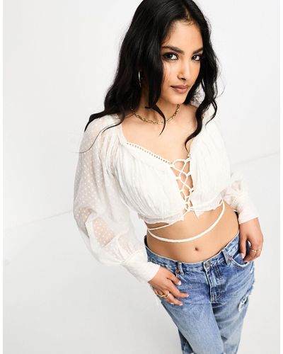 ASOS Crop top en plumetis à manches longues avec laçage à l'avant et détail volanté - ivoire - Blanc