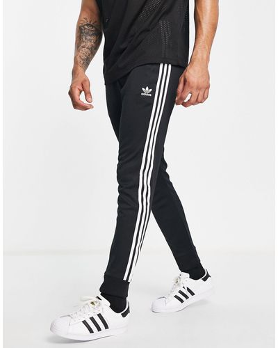 adidas Originals – adicolor – eng geschnittene jogginghose mit den drei streifen - Schwarz