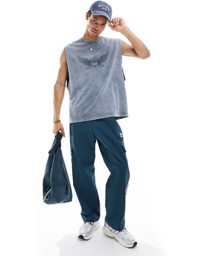 ASOS Camiseta azul lavado extragrande sin mangas con estampado estilo grunge en el pecho