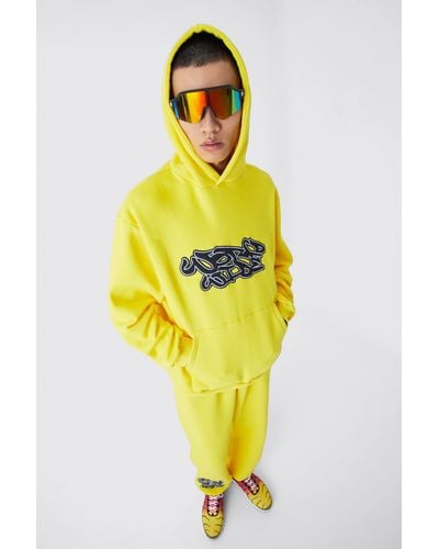 BoohooMAN Oversize Worldwide Trainingsanzug mit Graffiti-Print und Kapuze - Gelb