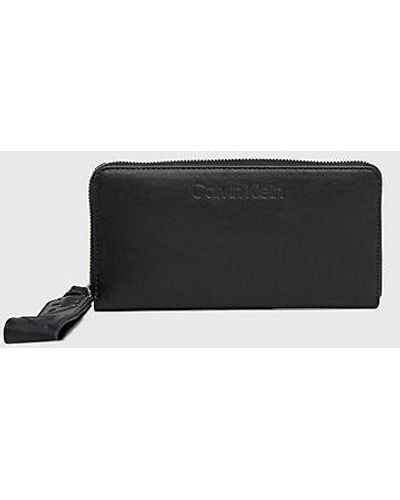 Calvin Klein Cartera con cremallera en el contorno y correa para la muñeca RFID - Negro