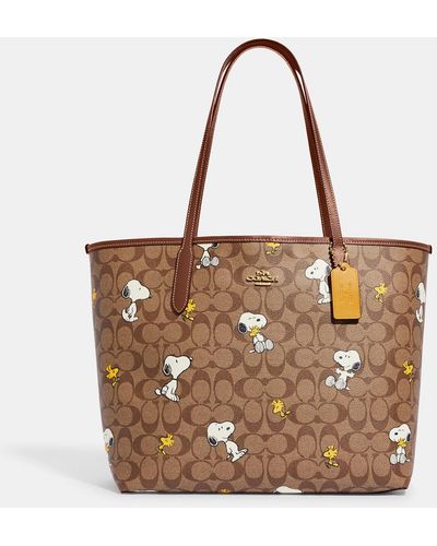 COACH Coach X Peanuts City Tote In Signature Canvas With Snoopy Woodstock Print - Brown