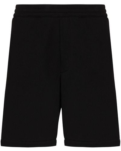 Alexander McQueen Pantalones de chándal con franjas del logo - Negro