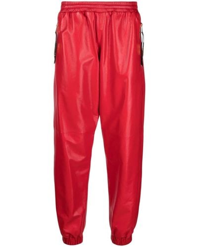 Moschino Pantalon de jogging en cuir à plaque logo - Rouge