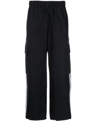 adidas Pantalones joggers anchos con franja lateral - Negro