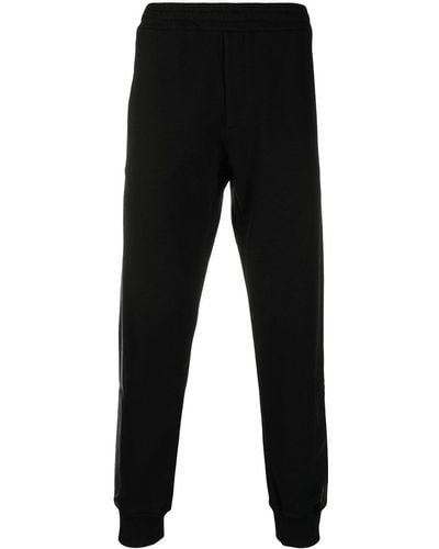 Alexander McQueen Pantalones de chándal con rayas laterales - Negro