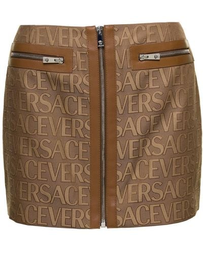Versace Minigonna con zip e stampa logo lettering all-over in canvas marrone donna