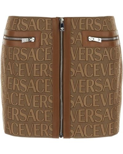 Versace Minigonna con zip e stampa logo lettering all-over in canvas marrone donna