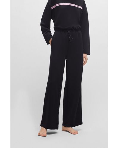 HUGO Pantalon de survêtement à bords bruts avec ruban à logo sur les coutures latérales - Noir