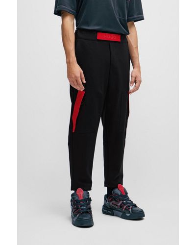 HUGO Pantaloni della tuta relaxed fit con banda con logo rossa - Nero