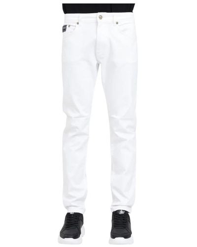 Versace Pantaloni bianchi slim fit con logo dorato - Bianco