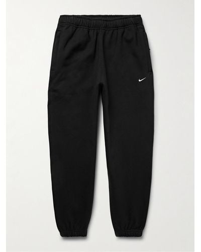 Nike Pantaloni sportivi a gamba affusolata in jersey di misto cotone con logo ricamato Solo Swoosh - Nero