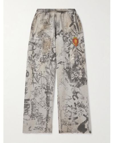 Balenciaga Weit geschnittene Jogginghose aus Baumwoll-Jersey mit Print und Logostickerei in Distressed-Optik - Grau