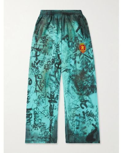 Balenciaga Weit geschnittene Jogginghose aus Baumwoll-Jersey mit Print und Logostickerei in Distressed-Optik - Blau