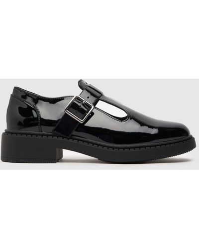 Schuh Leah Patent T-bar Flat Shoes In - Black