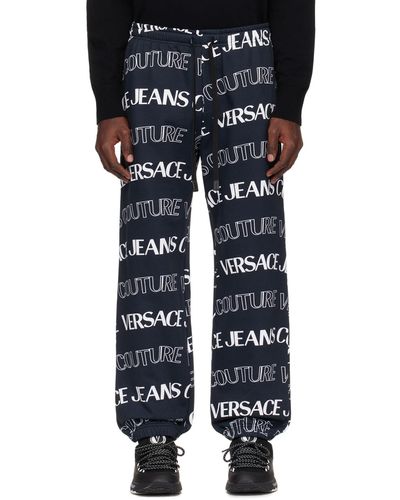 Versace Pantalon de survêtement noir et blanc à motif à logo modifié - Bleu
