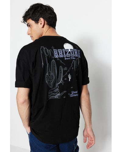 Trendyol Beigefarbenes t-shirt aus 100 % baumwolle mit tropischem arizona city-print in übergröße/weiter passform - Schwarz
