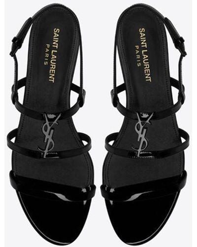 Saint Laurent Flache cassandra sandalen aus lackleder mit schwarzem monogramm schwarz