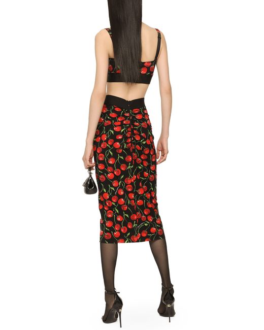 Jupe mi-longue en jersey technique avec élastique à logo et imprimé cerises Dolce & Gabbana en coloris Red