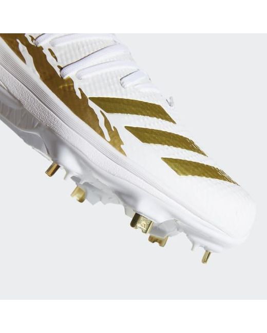 white and gold metal cleats