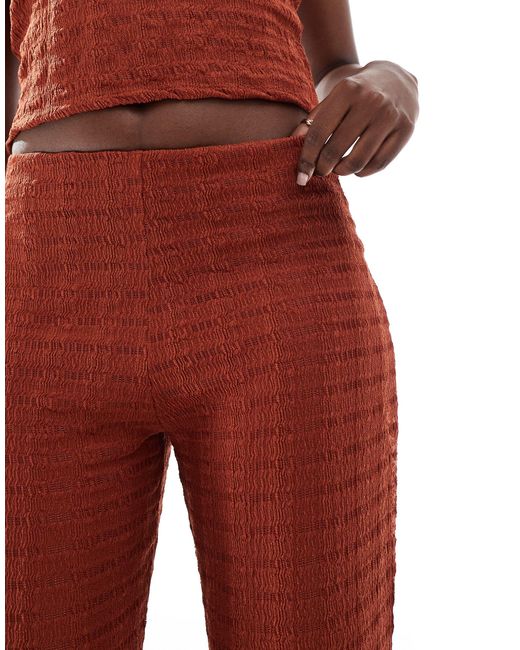 Pantaloni con fondo ampio color ruggine di ASOS in Red