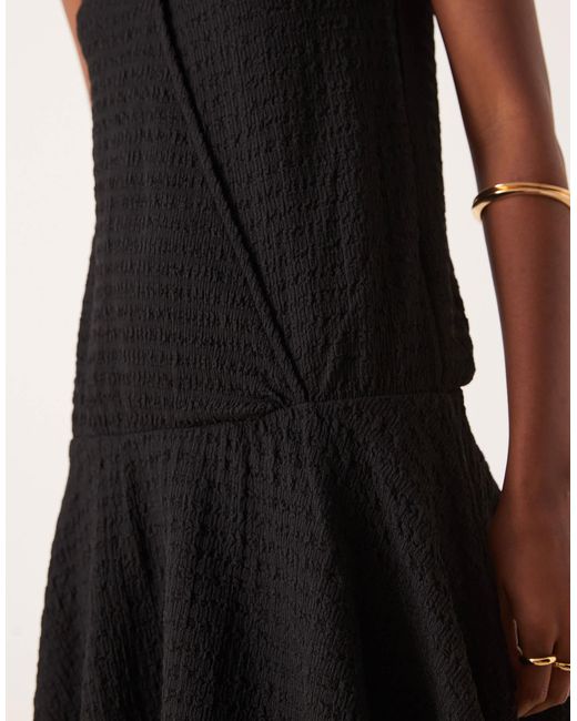 Robe courte sans manches texturée portefeuille à col v avec taille basse - noir ASOS en coloris Black