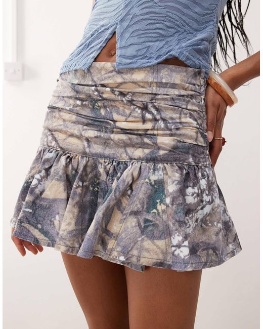 Mini-jupe froncée à taille basse avec motif camouflage Collusion en coloris Blue