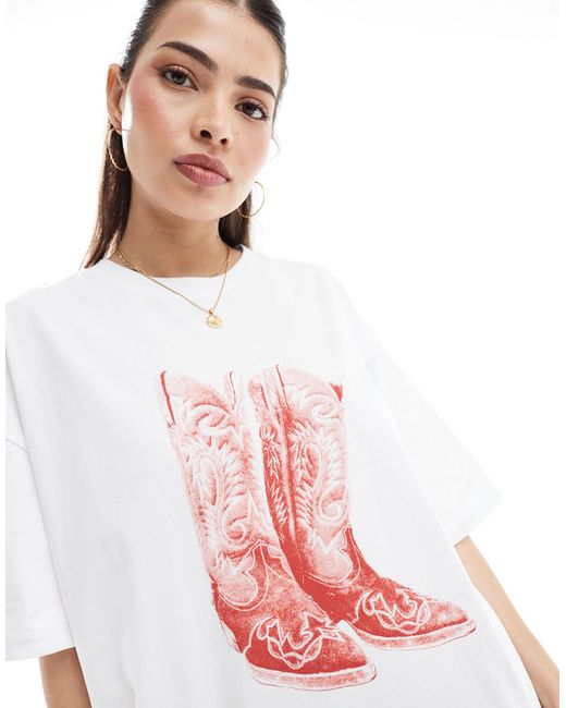 T-shirt oversize bianca con grafica di stivali da cowboy di ASOS in Pink