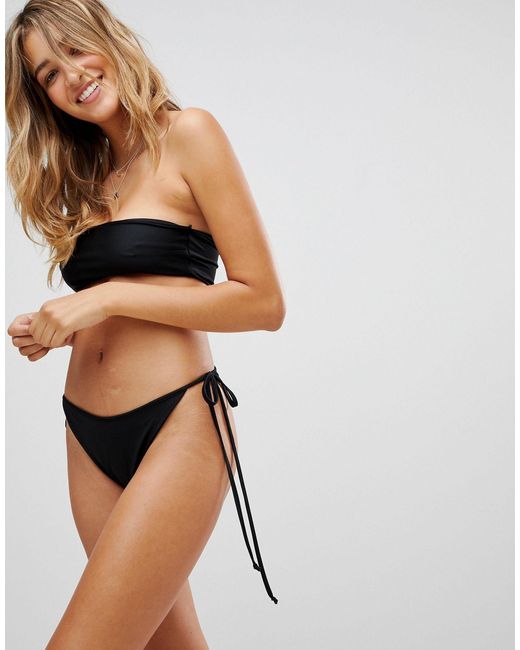 Slip bikini sgambato stile perizoma con laccetti laterali di  PrettyLittleThing in Nero | Lyst