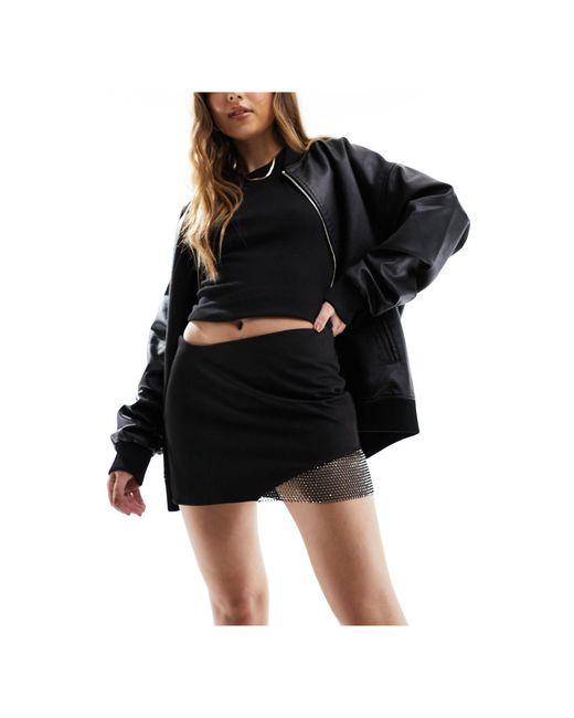 Mini-jupe ajustée à bords effet cotte Bershka en coloris Black