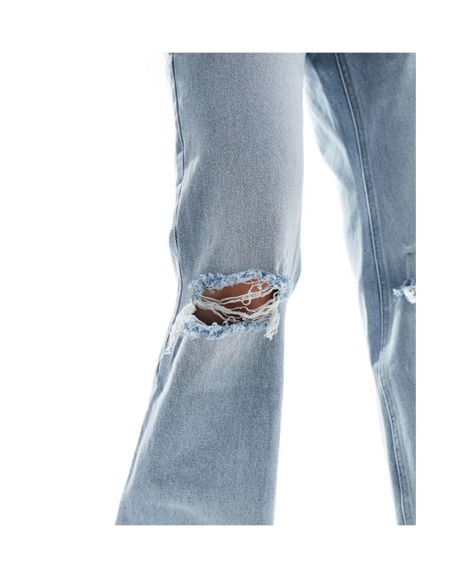 Jeans dritti a zampa lavaggio chiaro con strappi di Stradivarius in Blue